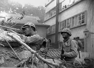 Backpacks: U.S. soldiers fire from behind a barricade at