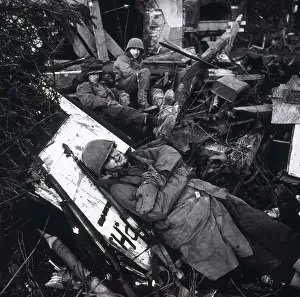 Lcgr1406: U.S. soldiers resting among ruins of building, with