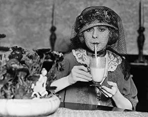 Intent: Veiled woman drinking beverage