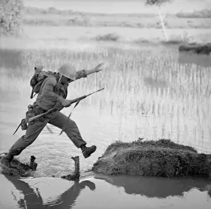 Leathernecks: Vietnam War. A US Marine rifleman leaps ?