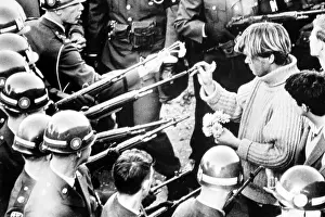 Protester: Vietnam War protester puts flowers into ?