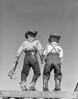 Crs001: Back view of two boys dressed in cowboy costume