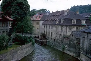 Dormer: View of a river with buildings and waterwheel