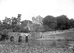 Eire: View of a stone arched bridge and ruined Abbey behind