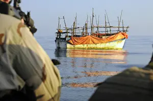 Dhow: Back view of U.S. sailors with weapons ready ?