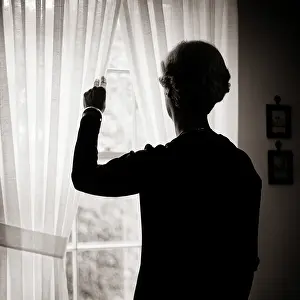 Reclusive: Back View of Woman Silhouetted Looking out Window