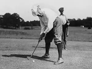 Putter: Warren G. Harding bending over to hit a golf