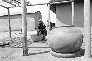 Homelands: Washing clothes in a courtyard with large clay pot