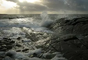 Galloway: Waves splash against the shining black rocks at Knockbrex