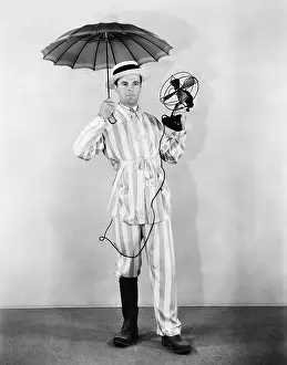 Witty: The weather man with umbrella, boot and fan