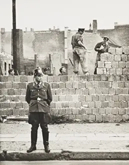 Cold War: West Berlin policeman stands before the concrete