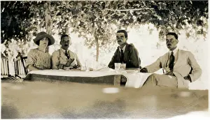 Sepia Images: Four Westerners at a table in the shade, Middle East