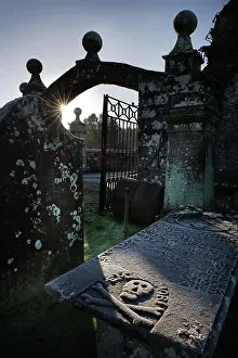 Fatal: Winter sun highlights a skull & crossbones on a tomb