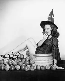 Wizardry: A wizardly woman takes a bite out of a big apple