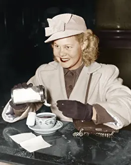 Teacup: Woman adding sugar to beverage