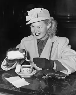 Teacup: Woman adding sugar to beverage