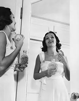 Smells: Woman applying perfume at mirror