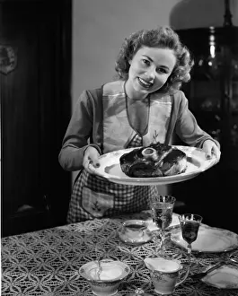 Camerique: Woman in apron serving up a plate of cooked ham