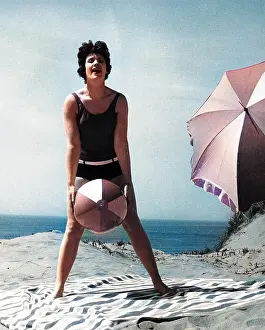 Andrew Besley: Woman on beach with ball and sunshade