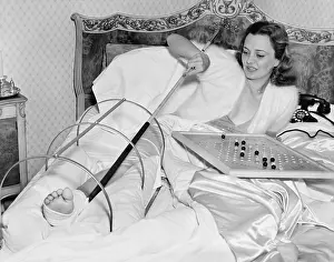 Adorn: Woman in bed trying to scratch her broken foot with a pole