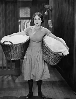 Overworked: Woman carrying laundry baskets