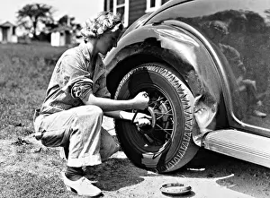 Wellings: Woman changing a tire, 1937