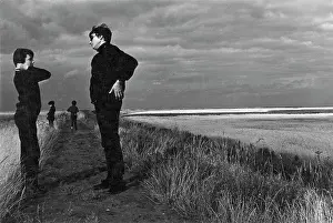 Costal: Woman and three children in a flat landscape