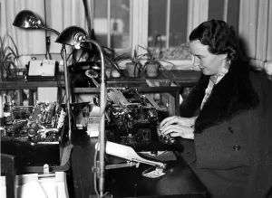 Shortage: Woman with coat in an office, 1940