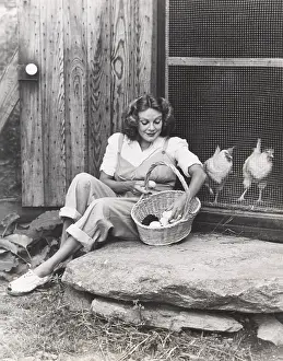 1910s 1940s: Woman collecting eggs from chickens