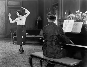 Showmanship: Woman dancing while her husband is playing the piano