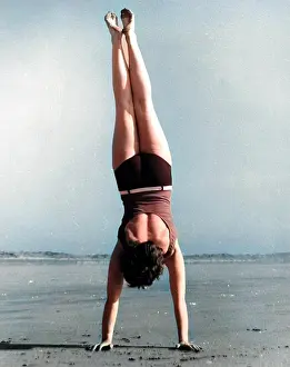 Andrew Besley: Woman doing handstand on beach