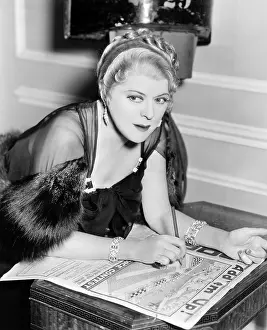 Focused: Woman doing puzzle in newspaper