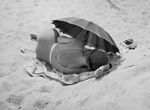 Dozing: Woman dozing on the beach, 1938