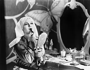 Lipsticks: Woman at dressing table applying cosmetics