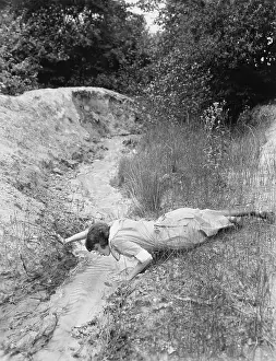 Resourceful: Woman drinking from tiny stream