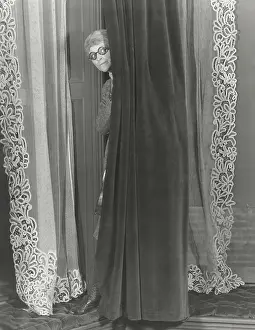 Nosey: Woman eavesdropping from behind curtain