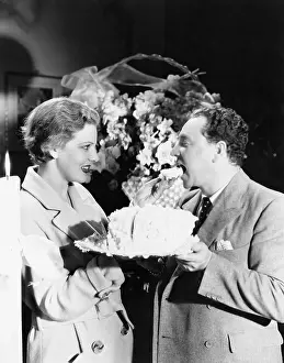 Trenchcoat: Woman feeding a man a piece of cake
