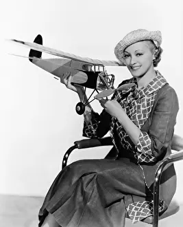 Miniatures: Woman holding model airplane