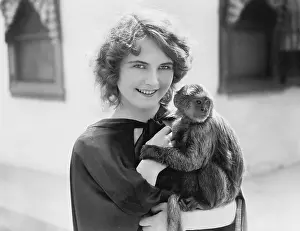 Capes: Woman holding a pet monkey in her arms
