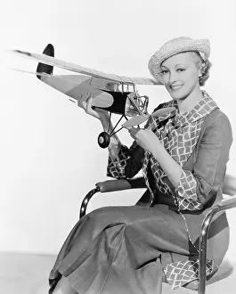 Raffia: Woman holding a toy plane