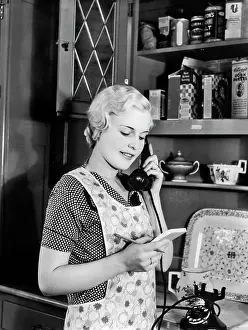 Homemaker: Woman Homemaker in Apron Standing in Kitchen Talking