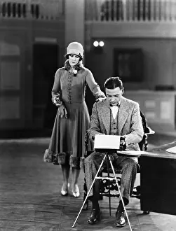 Professionals: Woman interrupting man at typewriter