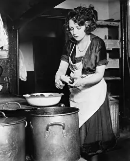 Peeling: Woman in a kitchen peeling potatoes