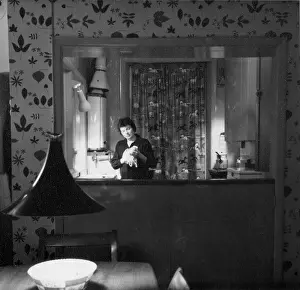 The John Krish Collection: Woman in a kitchen, viewed through a hatch