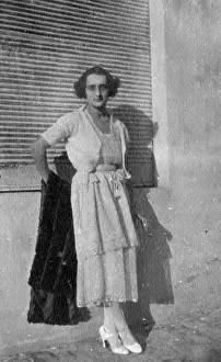 Leans: Woman leans against a wall