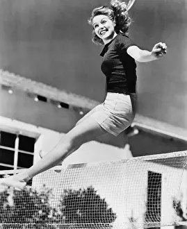 Vivacious: Woman leaping over a tennis net