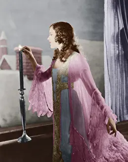 Snug: Woman lighting candle on winter evening