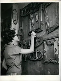Touched: Woman looking at display of frames and crosses