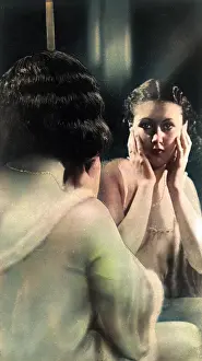 Scrutinising: Woman looking in a dressing table mirror