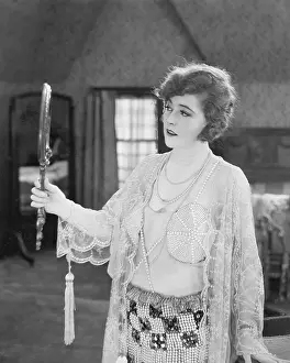 Noticing: Woman looking into a hand mirror